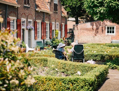 Deux dames âgées assises dans les jardins d'une maison de repos.