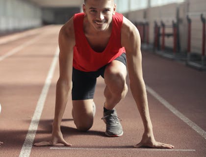 Um atleta se preparando para competir em uma pista de atletismo.
