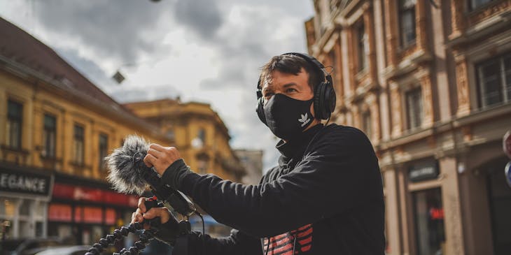 Person testing new audio equipment in the street outside an audio business.