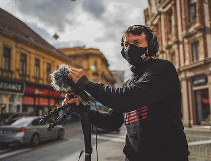 Person testing new audio equipment in the street outside an audio business.