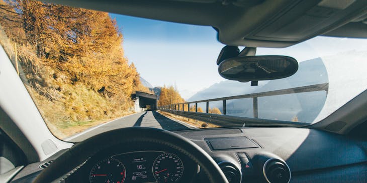 A view of a road and bridge through a windshield.