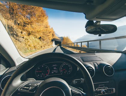 Vue d'une route et d'un pont à travers le pare-brise d'une voiture.