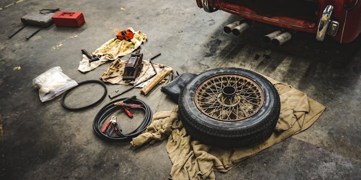 Tire and auto repair supplies next to a car.