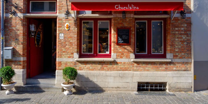 A red awning with Chocolalino label over a store window.