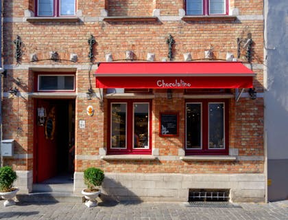 A red awning with Chocolalino label over a store window.