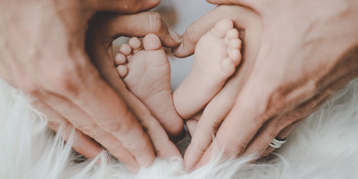 mother and father holding their baby's feet