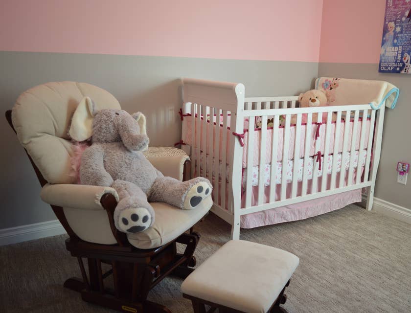 Cadeira de balanço ao lado de um berço em um quarto de bebê.