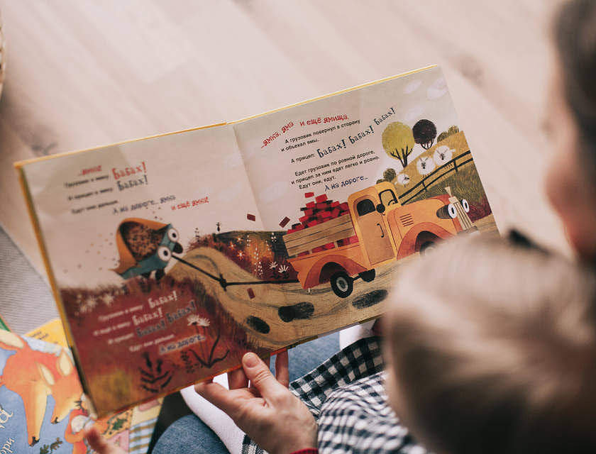 Institutriz leyendo un libro a un niño en empresa de cuidado de niños.