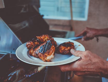 Un pollo arrosto servito sopra un piatto in una rosticceria.