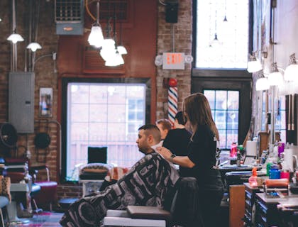 Coiffeur travaillant sur les cheveux d'un client masculin dans un salon de coiffure.