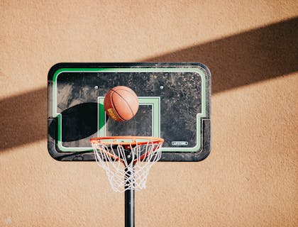 Una palla che entra nel cesto di un canestro in un campo da basket o pallacanestro.