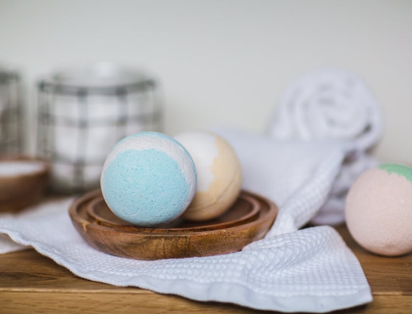 Trois bombes de bain colorées sur une table en bois.