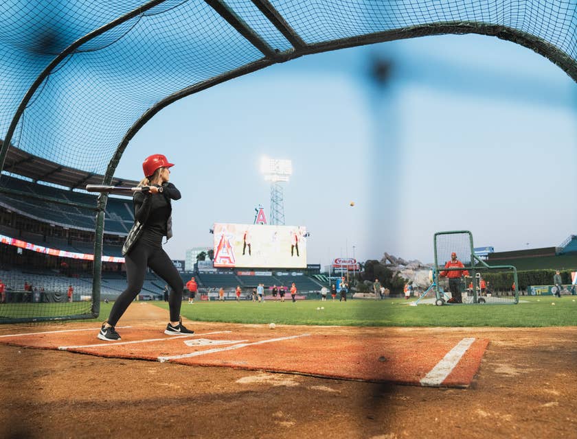 Una giocatrice di baseball che si allena in una batting cage.