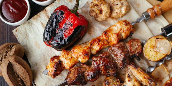 Platter containing grilled meats and vegetables.