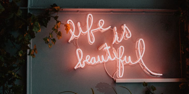 Pink neon sign of the words "life is beautiful".