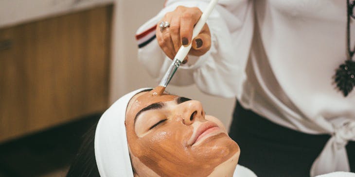 Women getting a mud facial at a beauty centre.