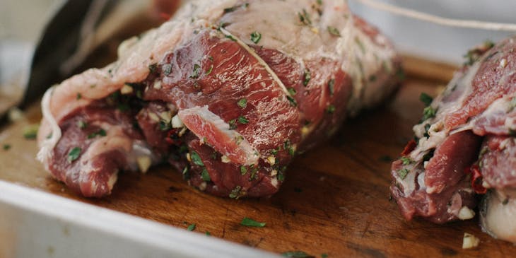Un operaio che taglia dei pezzi di carne in un'azienda di carne.