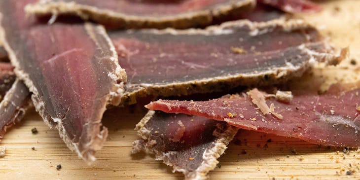Slices of beef jerky on a wooden chopping board displayed in a beef jerky business.