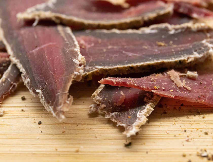 Slices of beef jerky on a wooden chopping board displayed in a beef jerky business.
