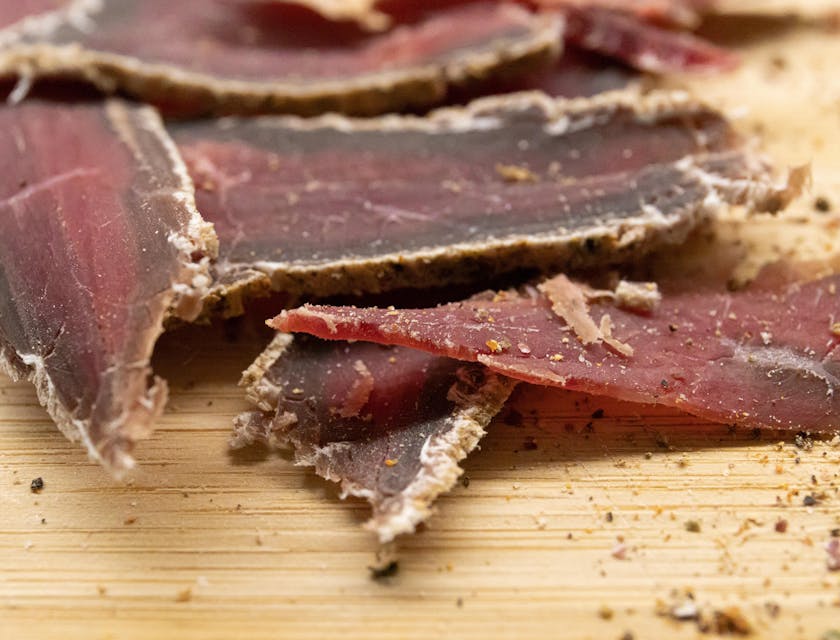 Slices of beef jerky on a wooden chopping board displayed in a beef jerky business.