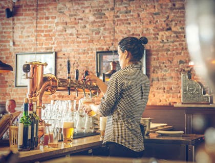 un barman sirviendo cerveza en un bar de cerveza