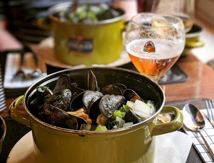 Un platillo belga acompañado por una copa de vino en un restaurante belga.