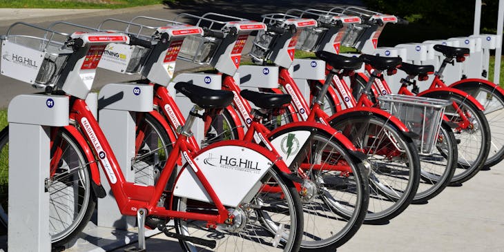 A row of red bicycles in front of a bike business.