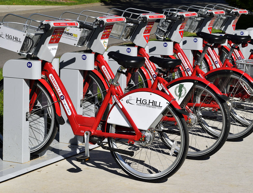 A row of red bicycles in front of a bike business.