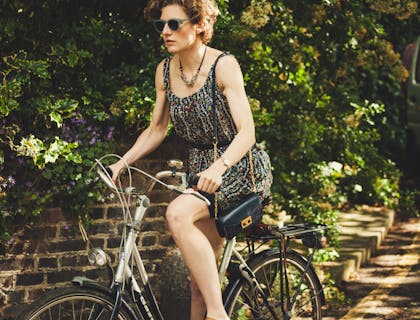 Mujer en un tour en bicicleta en una zona parcialmente sombreada.