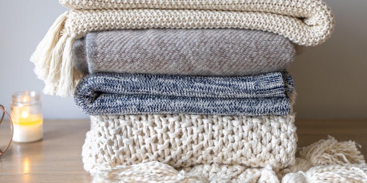 A pile of blankets for sale by a blanket business.