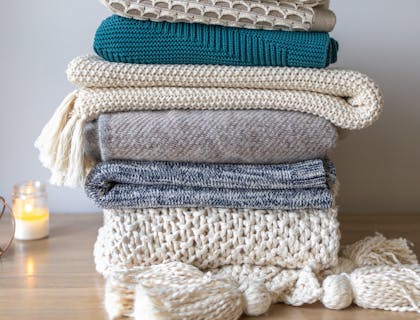 A pile of blankets for sale by a blanket business.