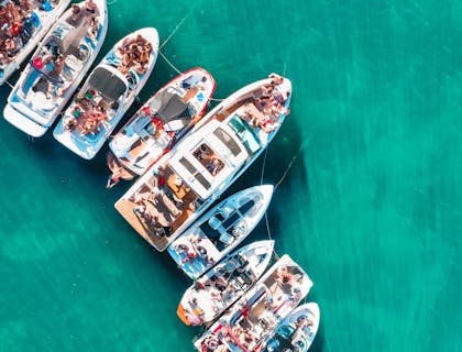 Barcos de festa disponíveis para locação no meio do mar.