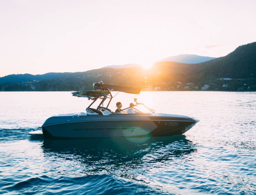 Un motoscafo nuovo che sfreccia al tramonto sull'acqua.