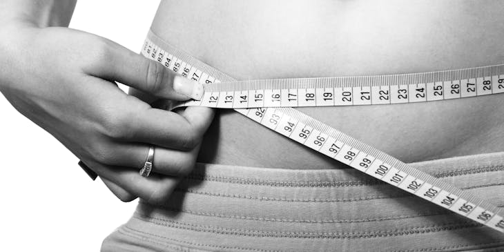 Person measuring belly at a body sculpting business.