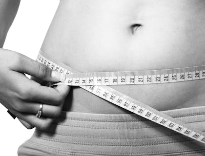 Pessoa medindo a barriga em uma clínica de criolipólise.