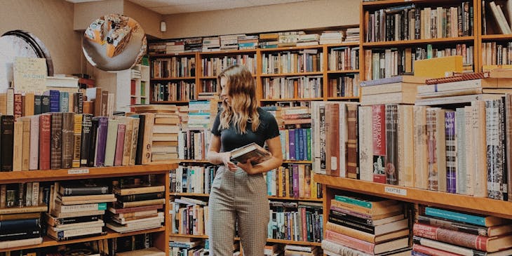 A woman surrounded by books in a book business.