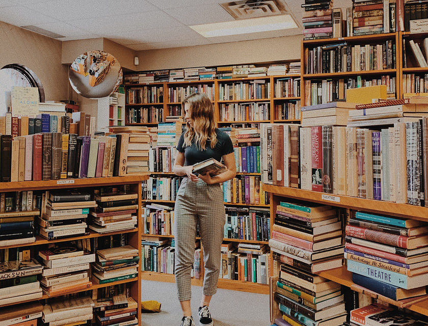 Una donna circondata dai libri in una libreria.