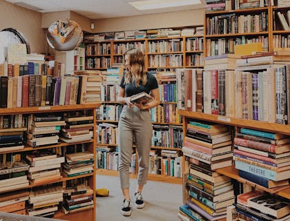 A woman surrounded by books in a book business.