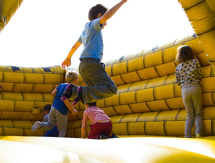 Niños saltando en un castillo de un negocio de inflables.