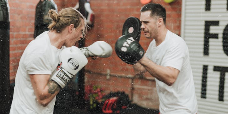 Two men performing boxing drills.