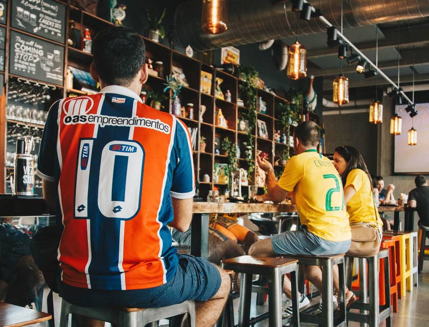 Delle persone sedute al bancone di un ristorante brasiliano che mangiano del cibo.