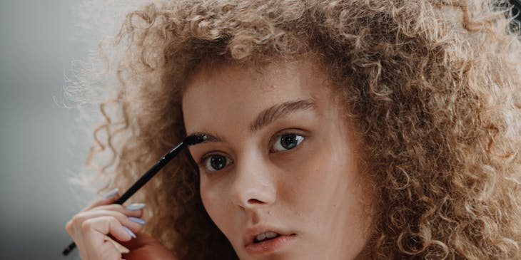 A woman brushing her eyebrows.