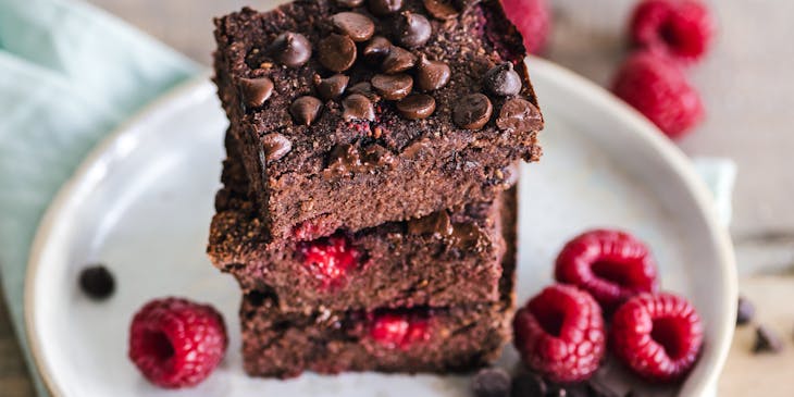 closeup of brownies and raspberries in a white plate