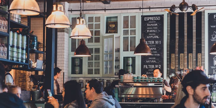 Um café com várias mesas cheias de clientes.
