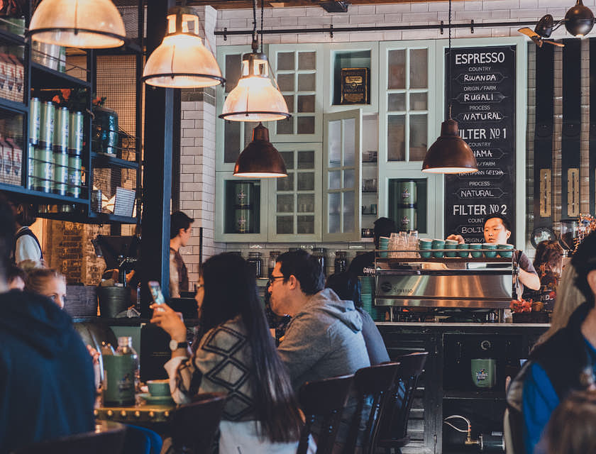 Un café avec plusieurs tables remplies de clients et clientes.