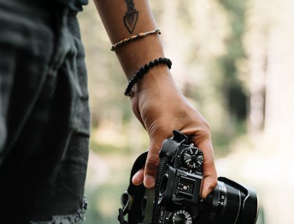 Pessoa segurando uma câmera fotográfica.