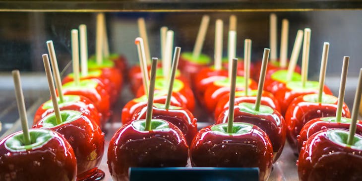 Tray of candy apples with a notecard saying "dipped apple"