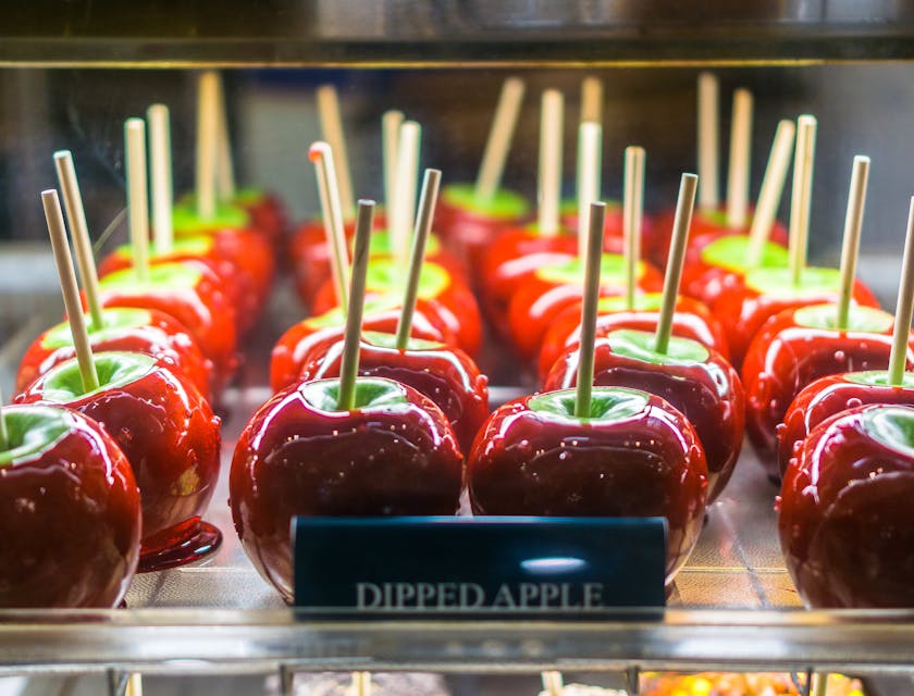 Tray of candy apples with a notecard saying "dipped apple"