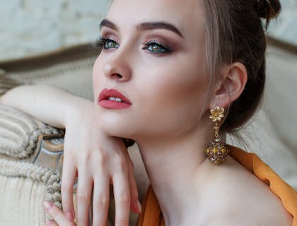 Uma mulher cativante com lábios rosados e brincos de ouro.