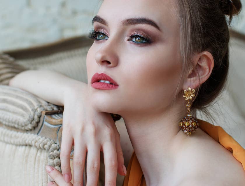 A captivating woman with pink lips and gold earrings.